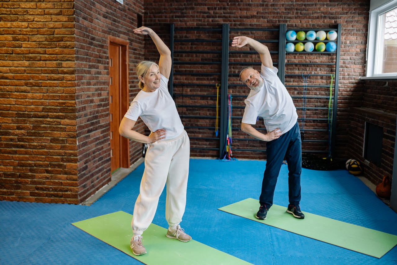 Home Elderly couple stretching on yoga mats in a home gym, embracing a healthy lifestyle.